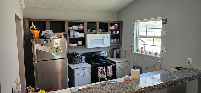 kitchen featuring lofted ceiling, stainless steel fridge, a textured ceiling, black / electric stove, and sink