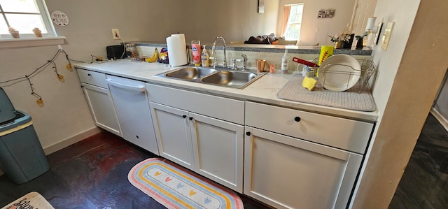 kitchen featuring white dishwasher, sink, and white cabinetry