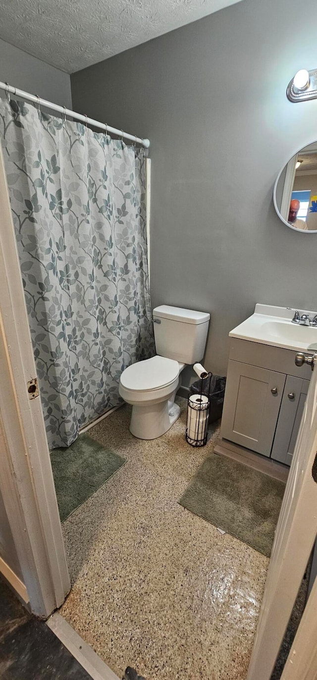 bathroom featuring vanity, toilet, a textured ceiling, and a shower with shower curtain