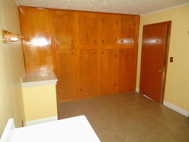 interior space featuring a textured ceiling and ornamental molding