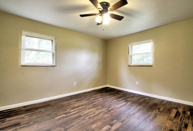 spare room with ceiling fan, a wealth of natural light, and dark hardwood / wood-style floors