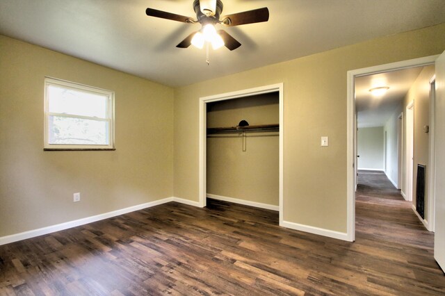 unfurnished bedroom featuring dark wood-type flooring, a closet, and ceiling fan