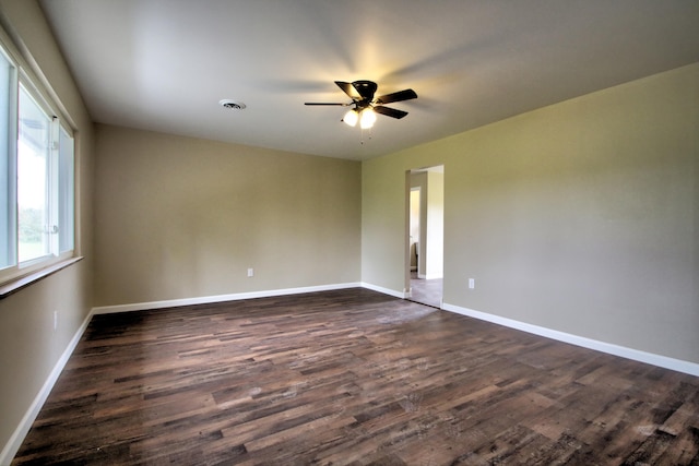 unfurnished room featuring dark wood-type flooring and ceiling fan