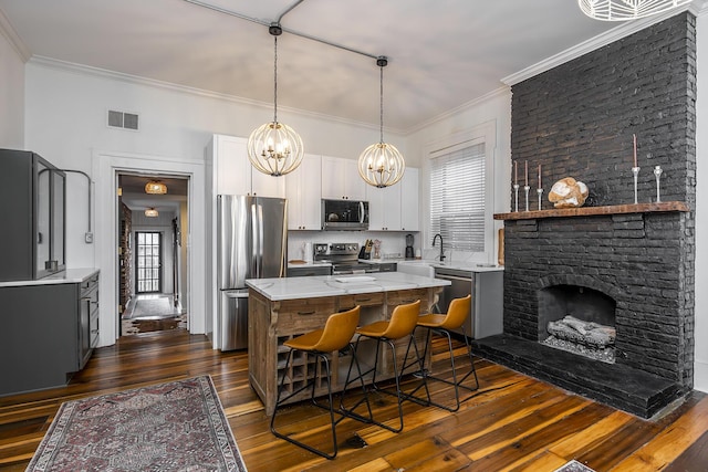 302 W High St, Lexington, KY 40507 - kitchen with stainless steel appliances, dark wood finished floors, crown molding, a center island, and a chandelier