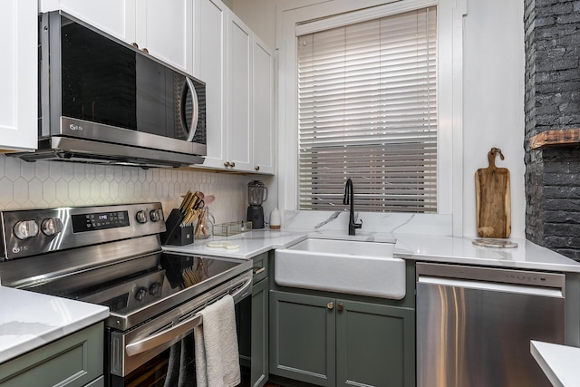 302 W High St, Lexington, KY 40507 - kitchen featuring appliances with stainless steel finishes, a sink, backsplash, white cabinetry, and light stone counters