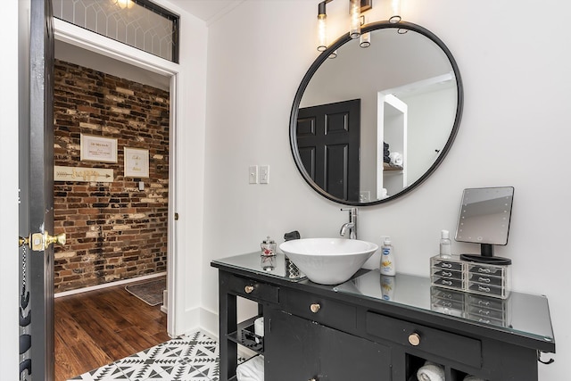 302 W High St, Lexington, KY 40507 - bathroom with brick wall, vanity, wood finished floors, and baseboards