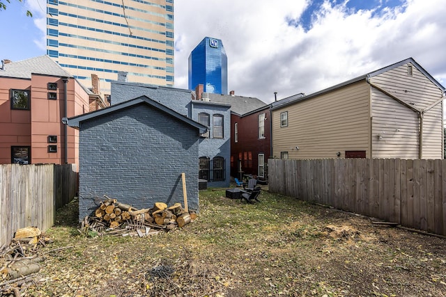 302 W High St, Lexington, KY 40507 - back of property featuring a chimney, a fenced backyard, and brick siding