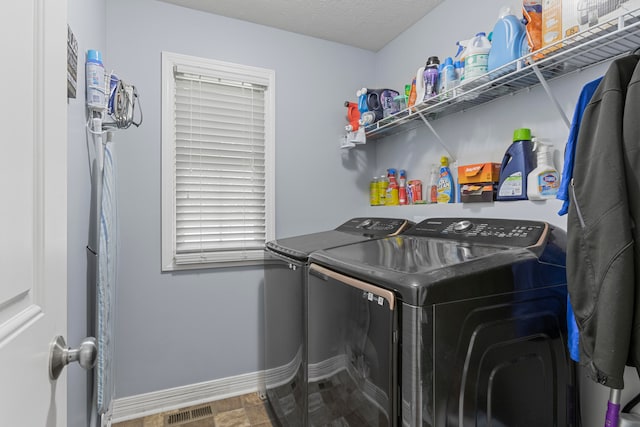 washroom featuring independent washer and dryer, a textured ceiling, and wood-type flooring