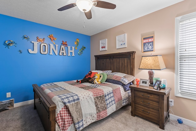 carpeted bedroom with ceiling fan and a textured ceiling