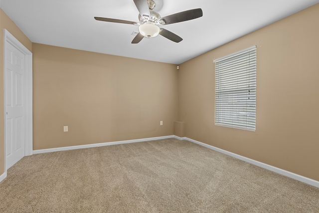 spare room featuring ceiling fan and carpet