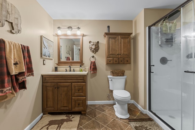 bathroom with a shower with door, vanity, toilet, and tile patterned flooring