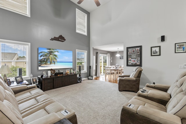 living room featuring carpet floors, a high ceiling, and ceiling fan