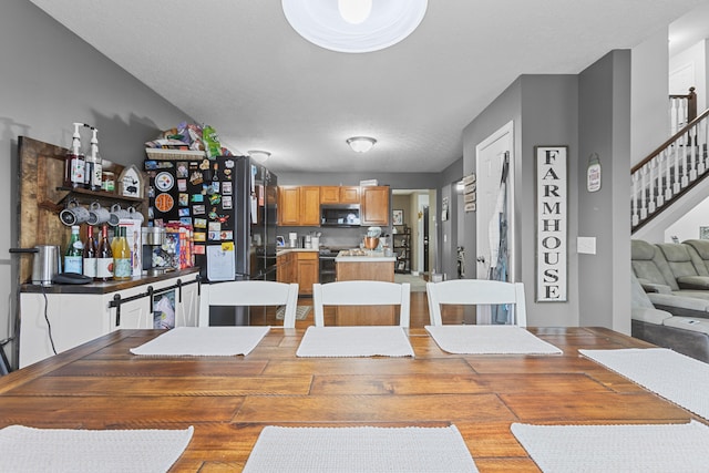 dining space featuring a textured ceiling and light wood-type flooring