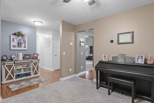 misc room featuring light hardwood / wood-style flooring, a textured ceiling, and ceiling fan