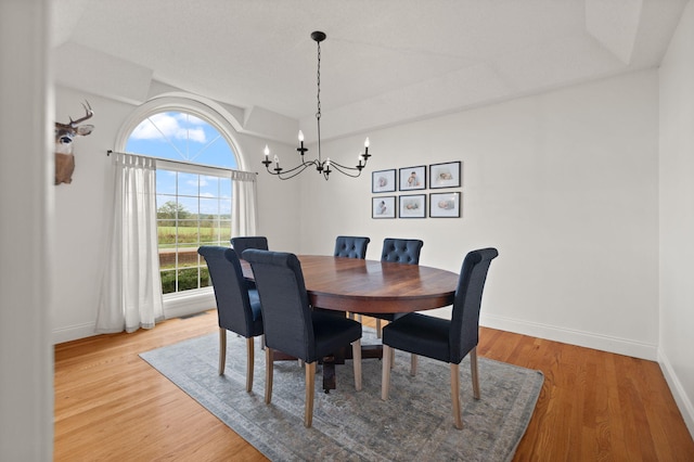 dining room with hardwood / wood-style floors and a chandelier