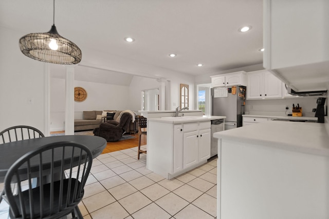 kitchen featuring white cabinetry, sink, pendant lighting, light hardwood / wood-style floors, and stainless steel appliances