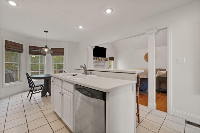 kitchen with sink, dishwasher, white cabinetry, decorative light fixtures, and a center island with sink