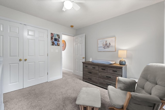 living area with light carpet and ceiling fan