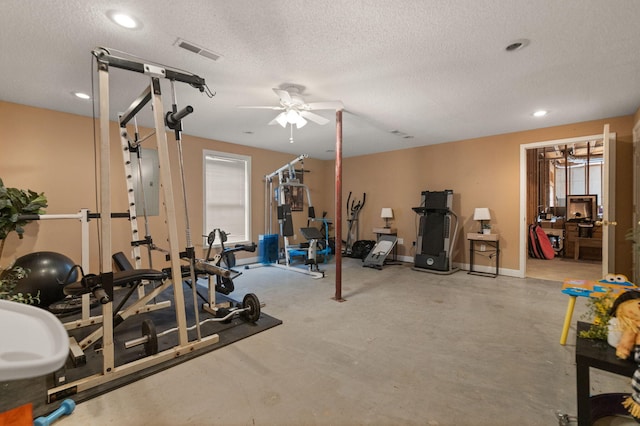 workout area featuring ceiling fan and a textured ceiling