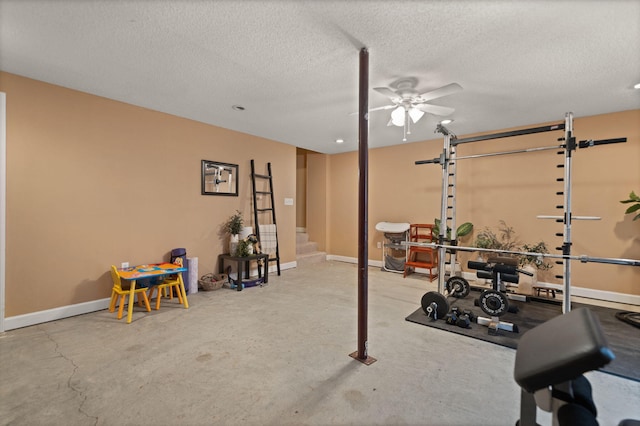 exercise room with ceiling fan, a textured ceiling, and concrete flooring