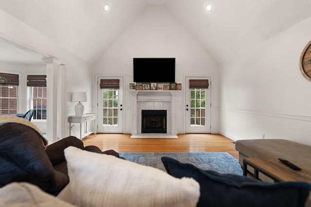 living room with a wealth of natural light, light hardwood / wood-style floors, and high vaulted ceiling