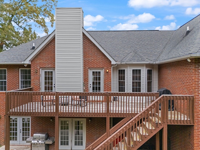 rear view of property with a wooden deck and french doors