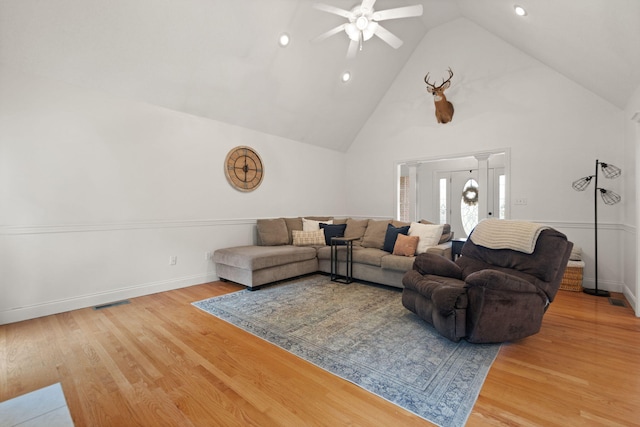 living room featuring hardwood / wood-style flooring, high vaulted ceiling, and ceiling fan