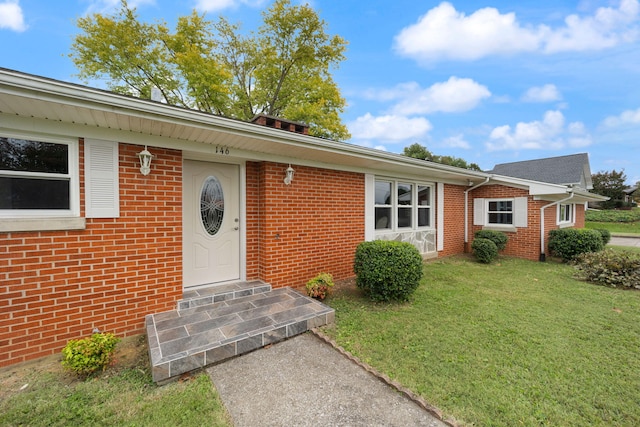 property entrance with a lawn