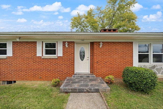 doorway to property featuring a lawn