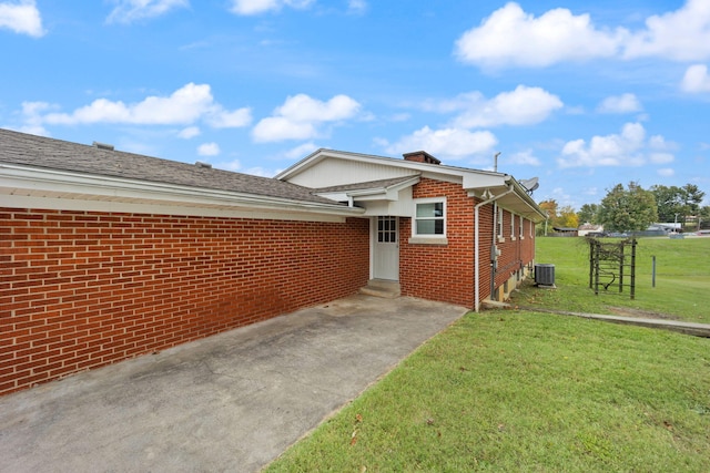 exterior space with cooling unit and a lawn