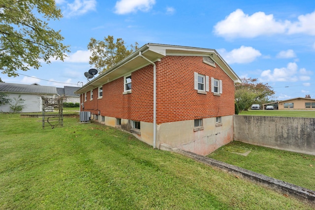 view of side of home featuring a yard and cooling unit