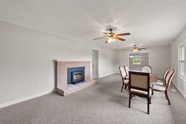 carpeted dining space featuring a wood stove and ceiling fan