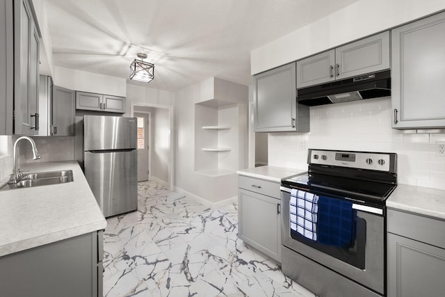 kitchen with sink, appliances with stainless steel finishes, gray cabinetry, and backsplash