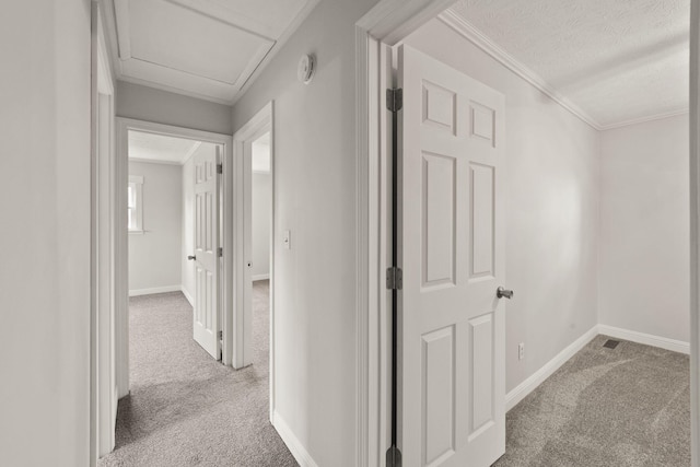 hall with crown molding, light carpet, and a textured ceiling