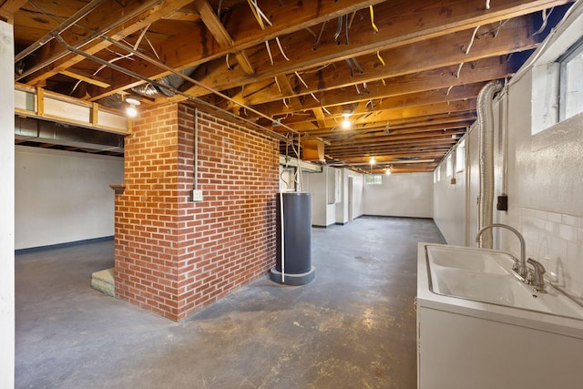 basement featuring brick wall, sink, and gas water heater