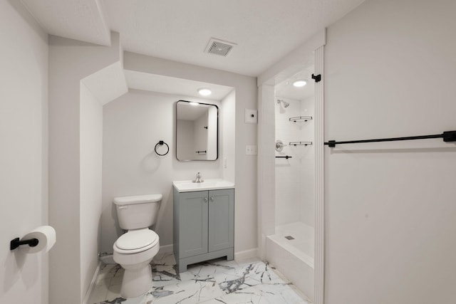 bathroom featuring vanity, toilet, and a tile shower