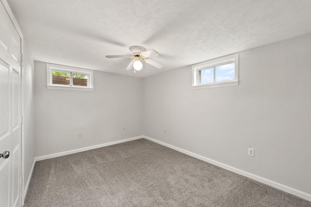 carpeted empty room featuring a textured ceiling and ceiling fan