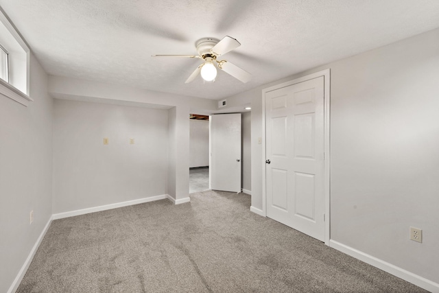 unfurnished bedroom featuring carpet, a textured ceiling, and ceiling fan