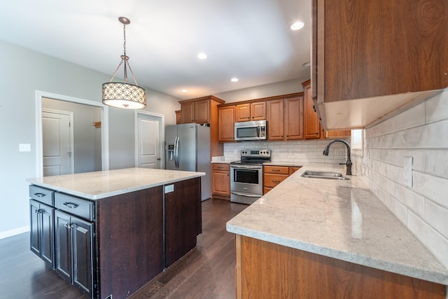 kitchen featuring stainless steel appliances, sink, light stone countertops, a center island, and dark hardwood / wood-style flooring