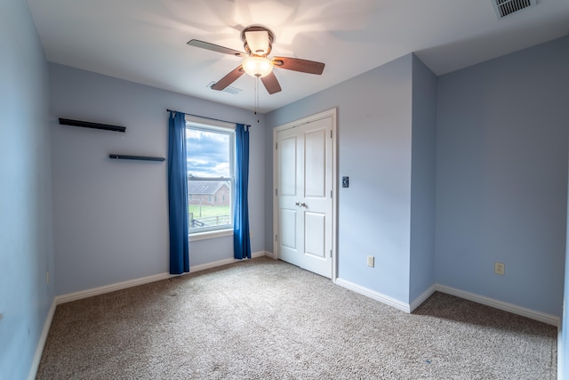 carpeted empty room featuring ceiling fan