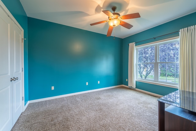 carpeted spare room featuring ceiling fan