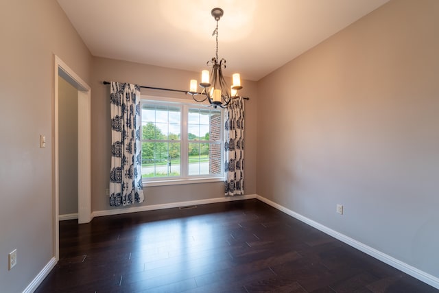 unfurnished room featuring a chandelier and dark wood-type flooring