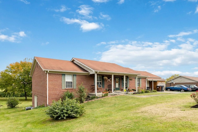 ranch-style home featuring covered porch and a front lawn