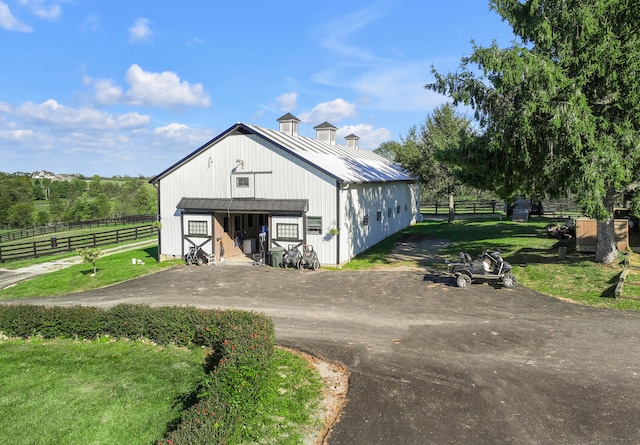 view of outdoor structure with a yard and a rural view