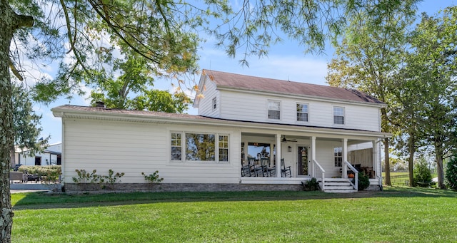 view of front of home with a front yard, covered porch, and ceiling fan