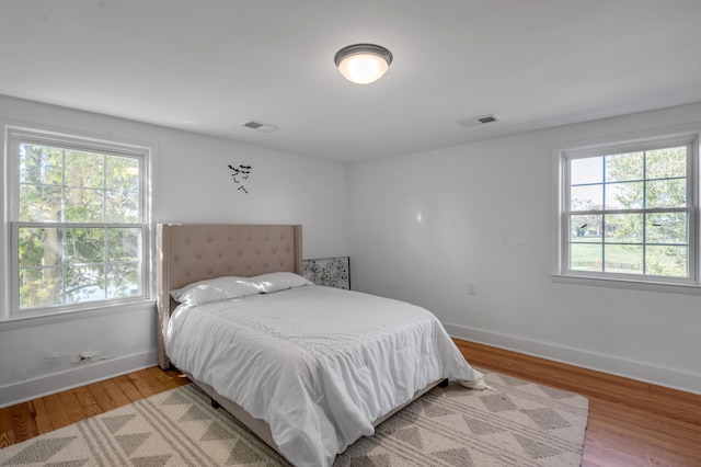 bedroom featuring multiple windows and light wood-type flooring