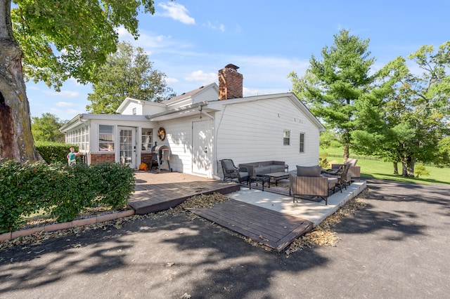 rear view of property with an outdoor living space and a deck