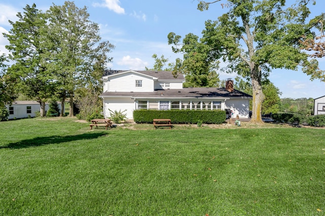 rear view of property featuring a yard