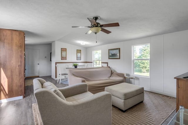 living room with lofted ceiling, a textured ceiling, hardwood / wood-style flooring, and ceiling fan