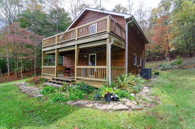 view of front of home with a wooden deck, a front yard, and central AC unit